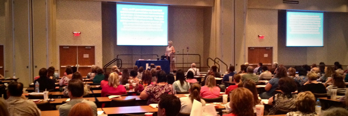 Dr. Linda Shell presenting to a large conference audience