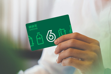 Hand holding a green Greens loyalty card