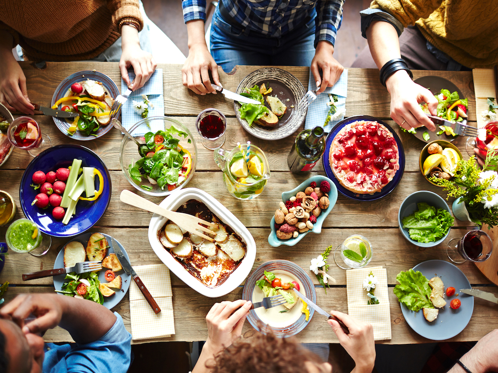 Overhead shot of a group sharing a large plant-based meal