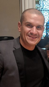 Frank Gonzalez, founder and principal broker of Loisaida Realty, in a grey blazer over a black shirt
