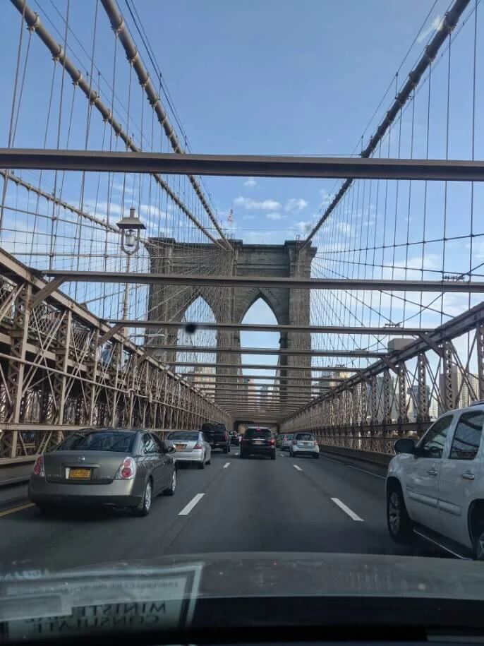 Driving across the Brooklyn Bridge, stone tower and cables