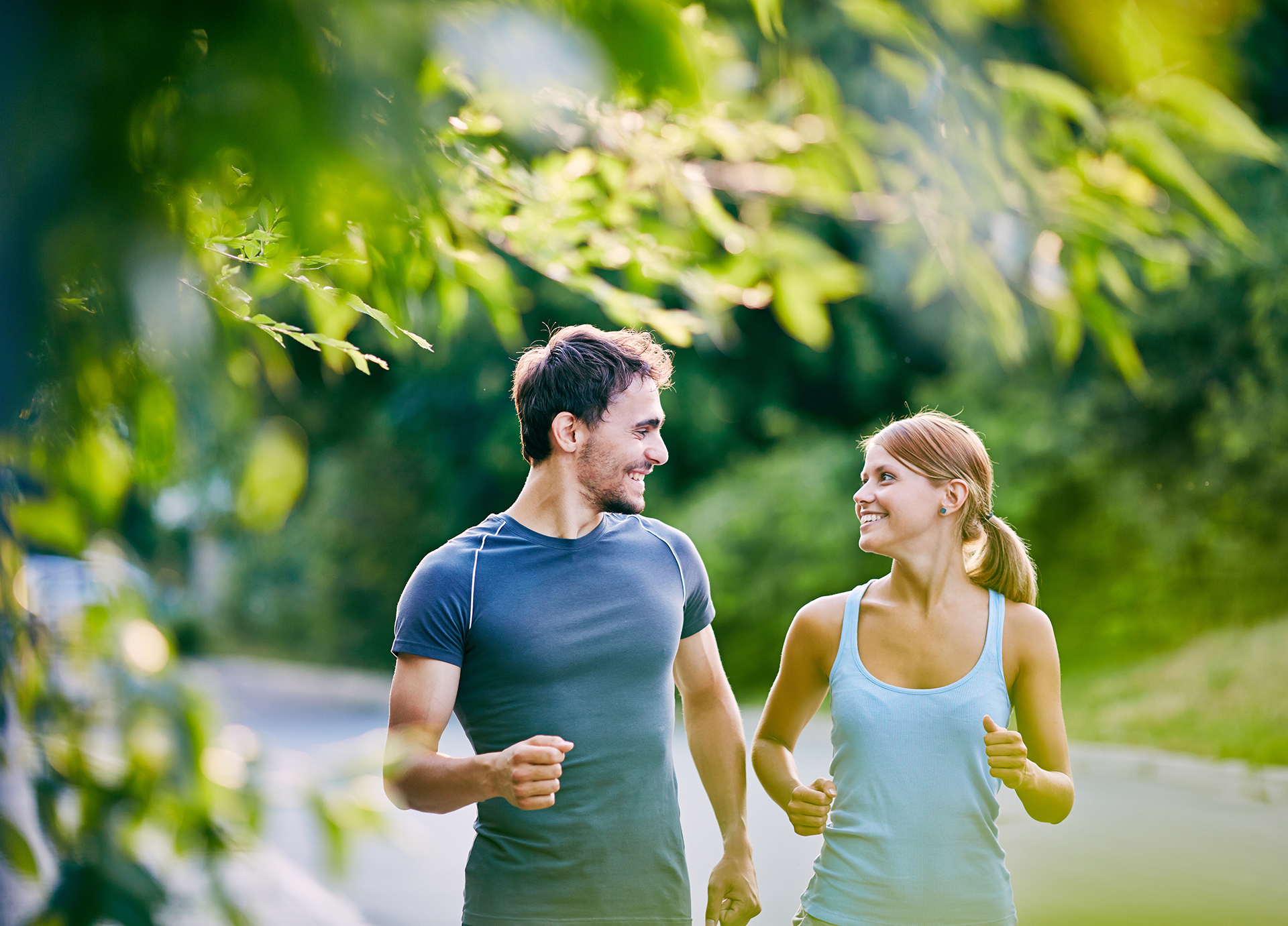 Smiling man and woman jogging together outdoors