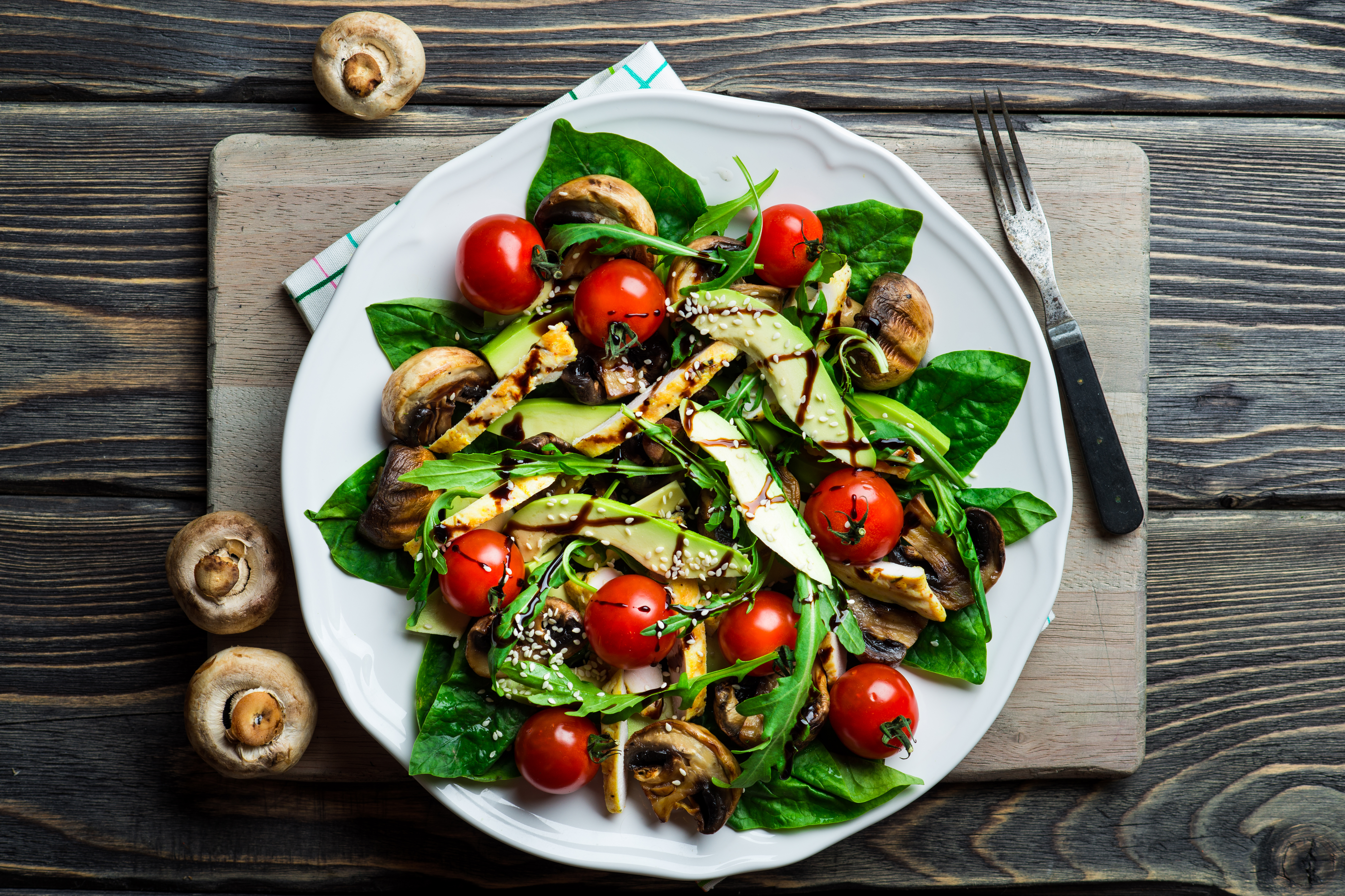 Overhead flat-lay of a fresh salad with tomatoes, mushrooms and avocado