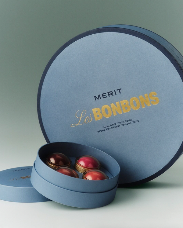 Merit Les Bonbons flush balm in a blue round gift box with gold lettering.