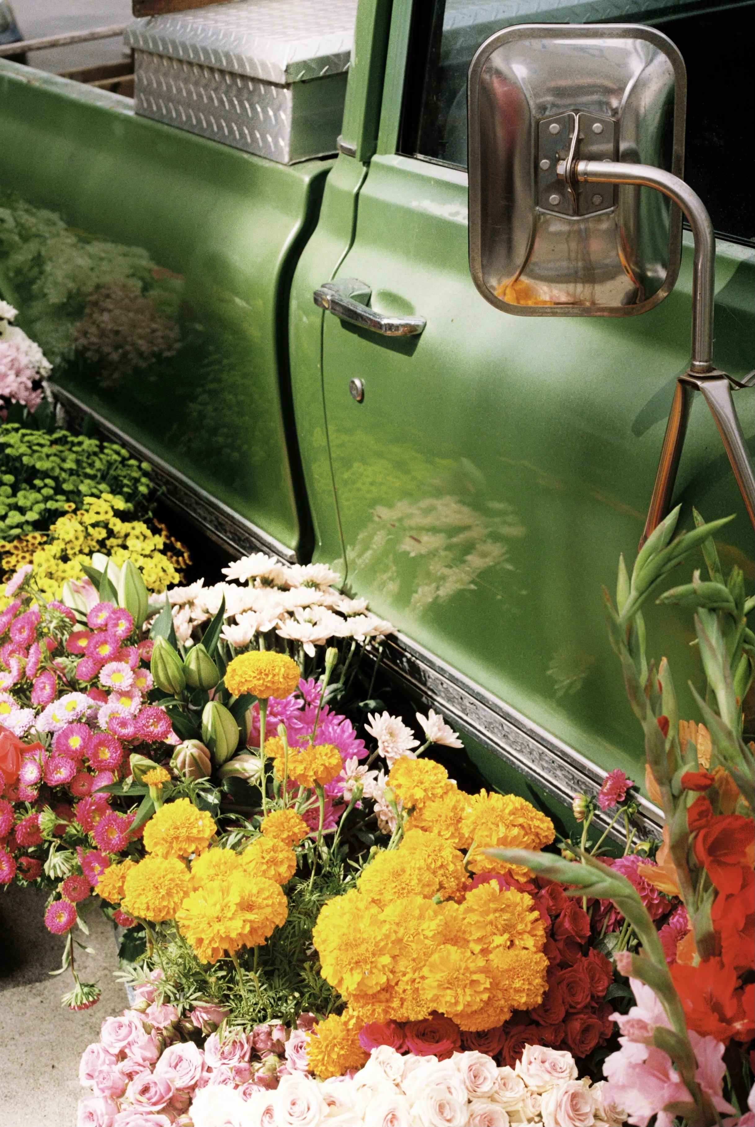 Marigolds, roses and daisies banked against the green door of the flower truck.