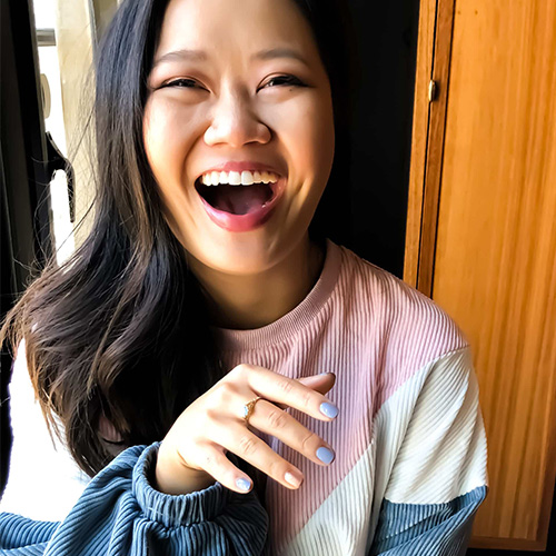 Laughing woman showing a light-blue manicure