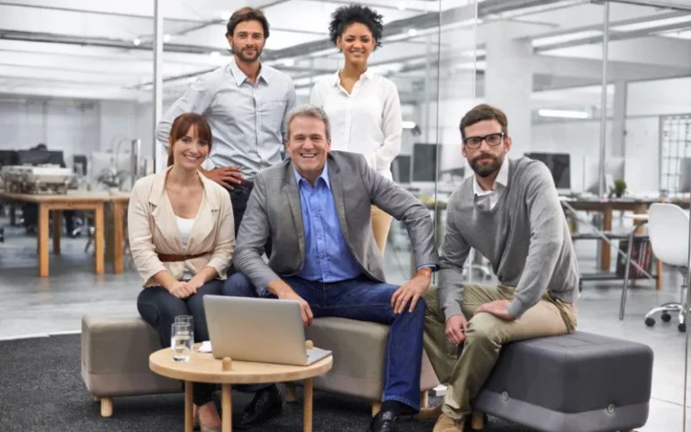 Group of five business professionals in a modern open-plan office