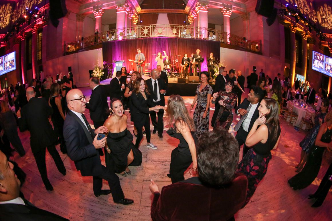 Gala dance floor under pink uplighting, wider angle