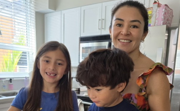 Woman and two children smiling in a kitchen
