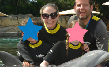 Couple with two children in wetsuits at the Discovery Cove dolphin swim