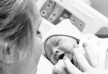Black-and-white photo of a mother with her newborn in the hospital