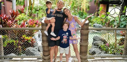 Family of four posing on a bridge in a tropical resort park