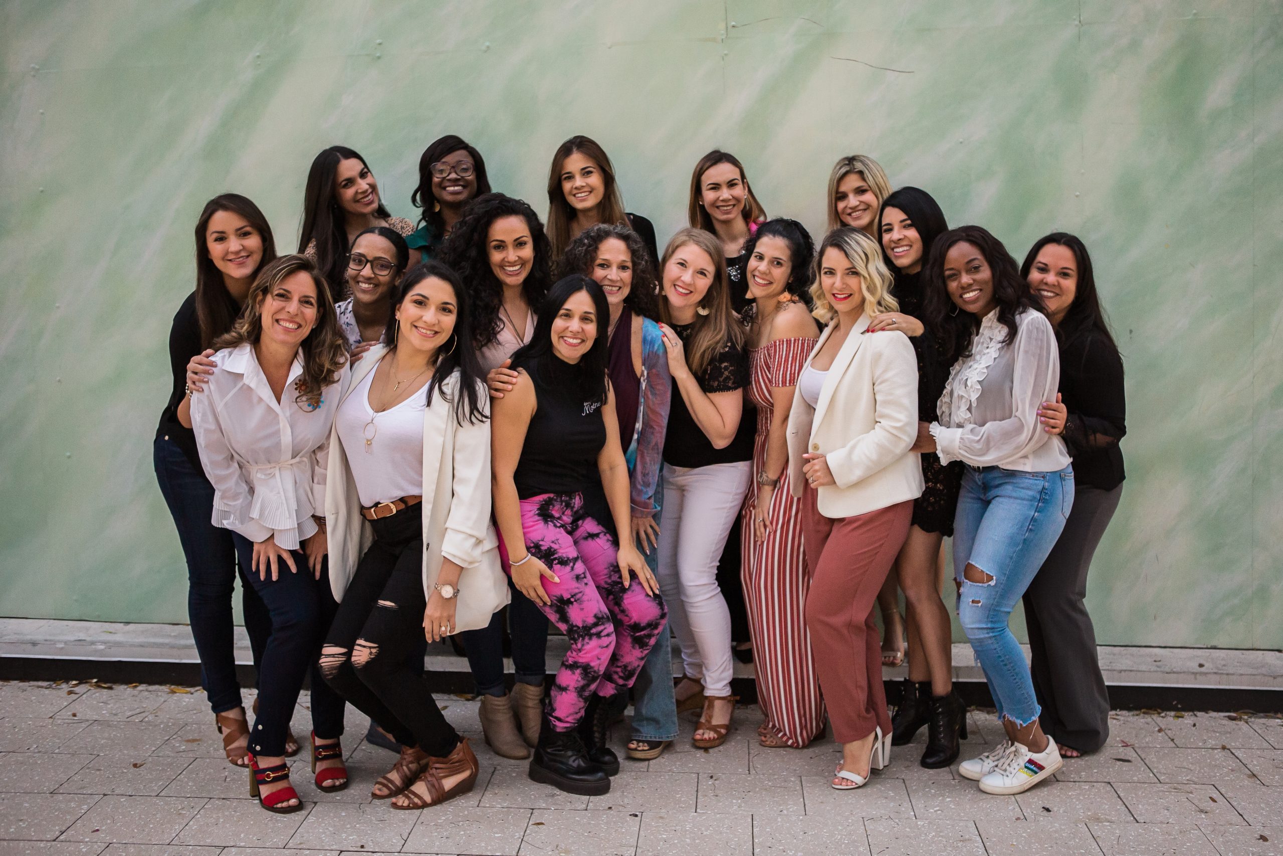 The Miami Mom Collective team of about 16 women posing together