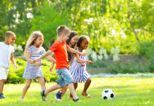 Diverse group of children playing soccer in a park