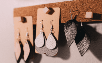 Leather teardrop earrings displayed on a cork board