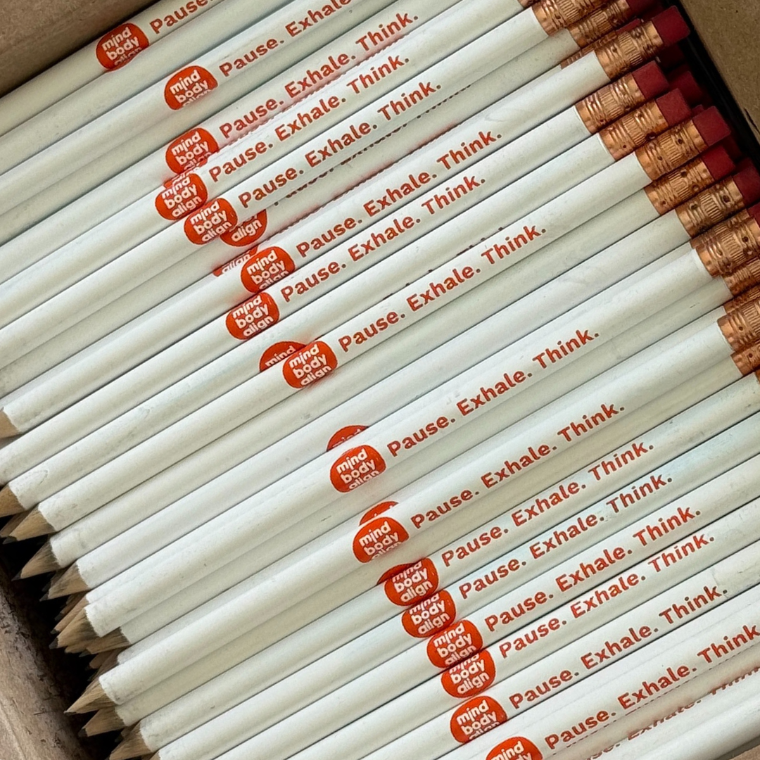 Box of white pencils printed with Mind Body Align — Pause. Exhale. Think.
