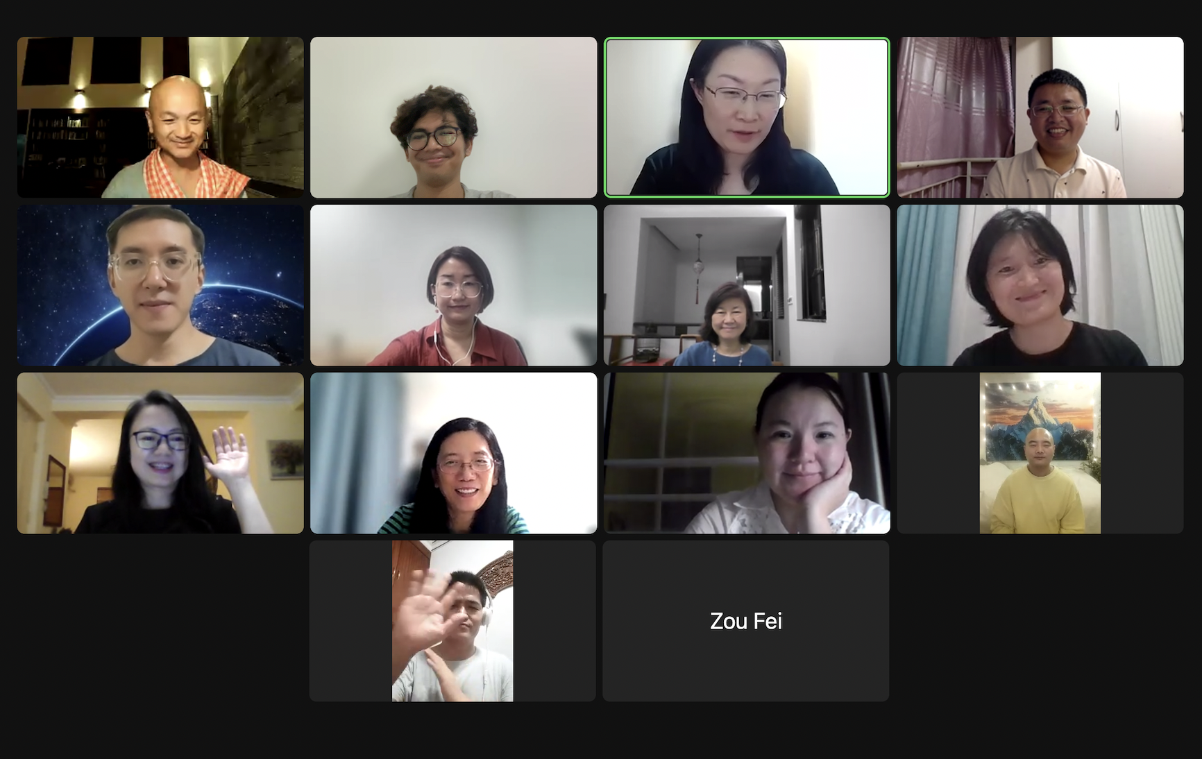 Zoom video call grid of participants with the facilitator in an orange robe