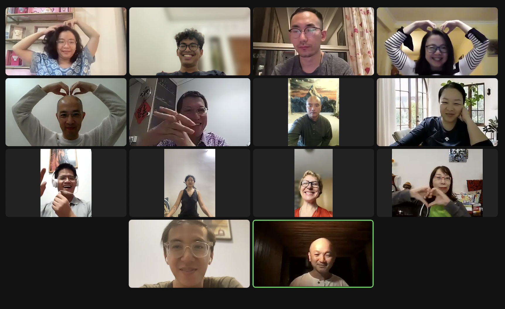 Zoom video call grid of participants making heart gestures with their hands