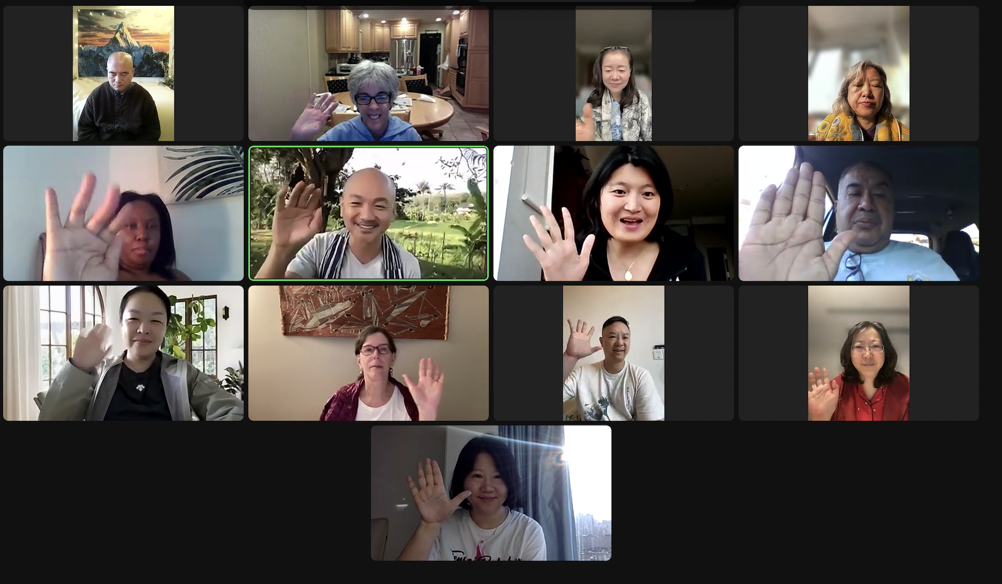 Zoom video call grid of about 13 MindKindness participants waving, with the facilitator highlighted