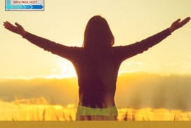 Silhouette of a woman with arms spread wide in a sunset field