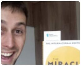 Young man holding The Miracle Morning book