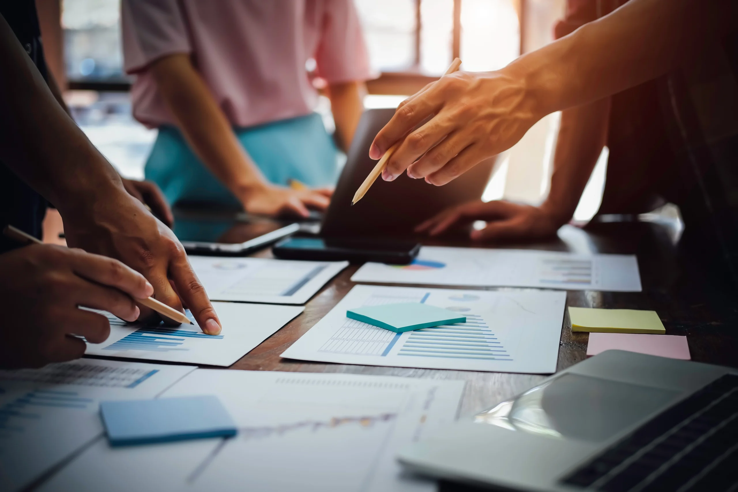 Team members pointing at charts and documents in a business meeting