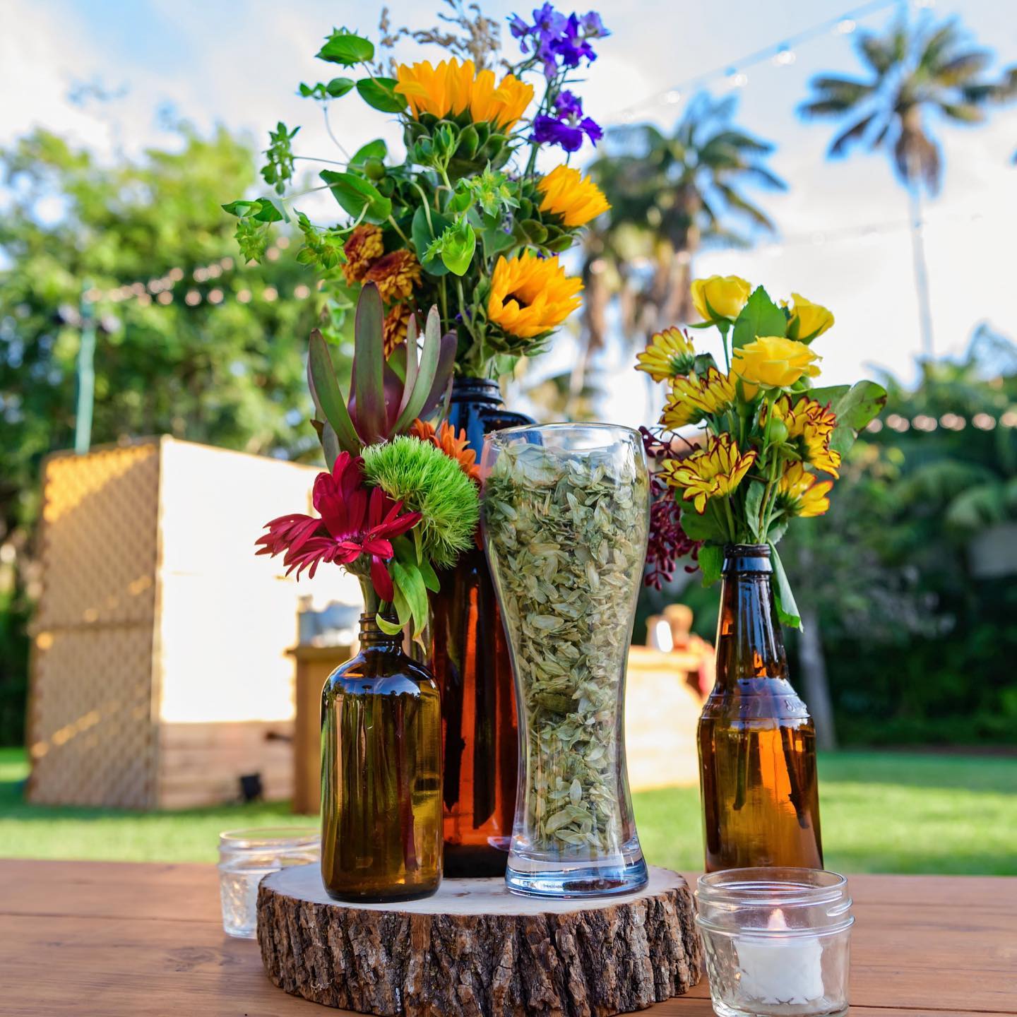 Floral centerpiece in amber bottles at a garden event