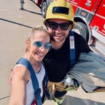 Guests in firefighter gear near a fire truck at an event