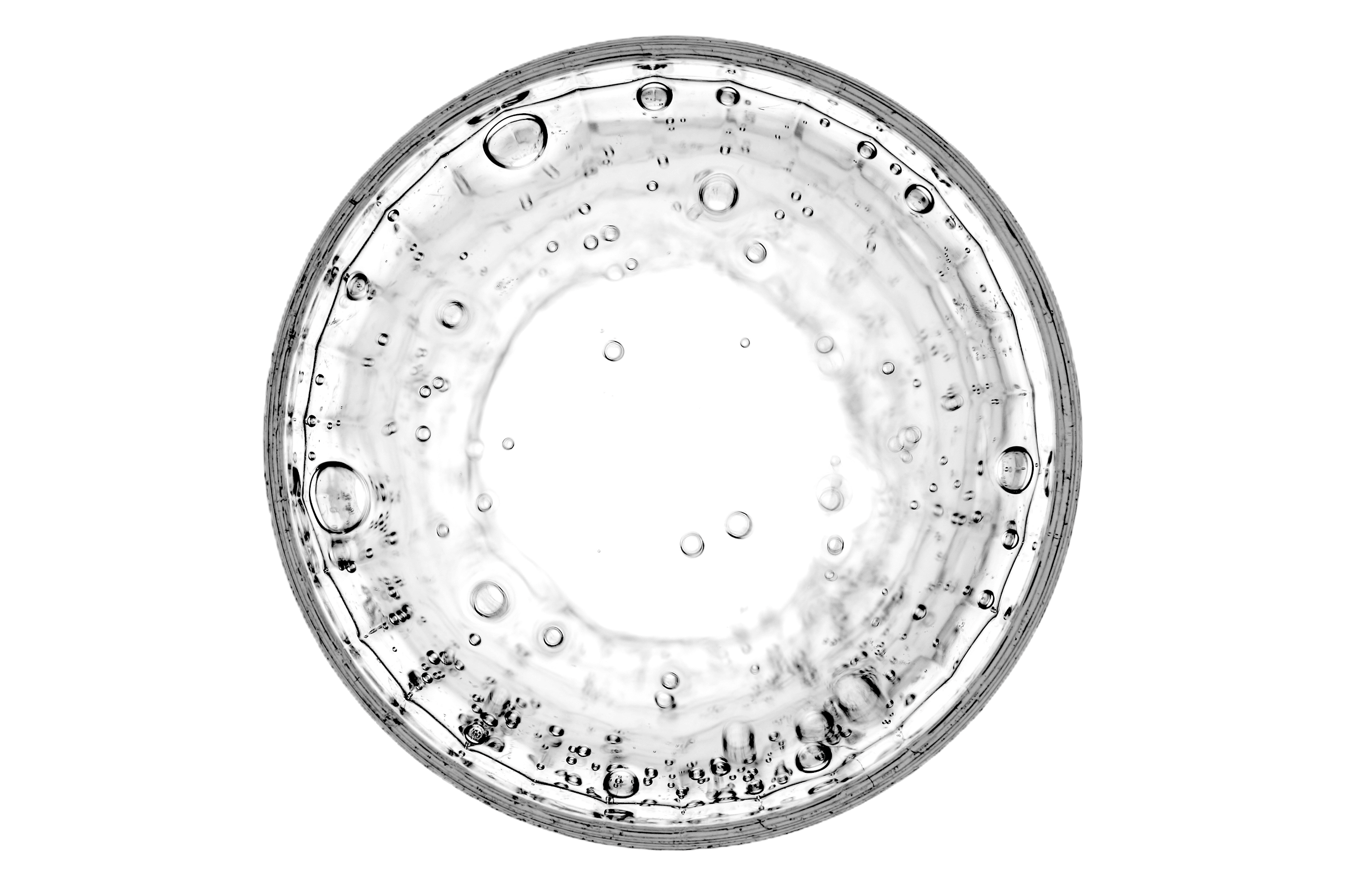 Macro photograph of a petri dish showing concentric rings and bubbles in liquid