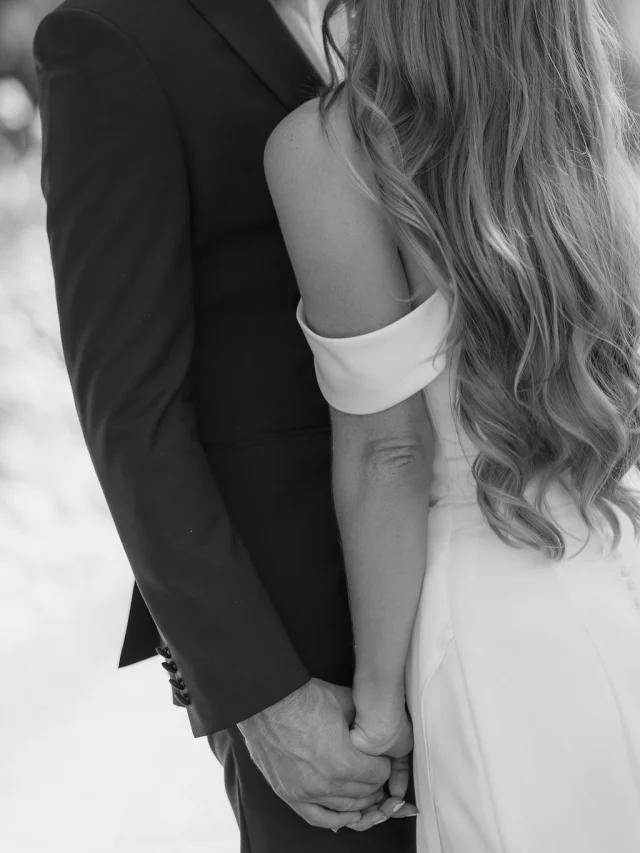 Black-and-white close-up of a couple holding hands