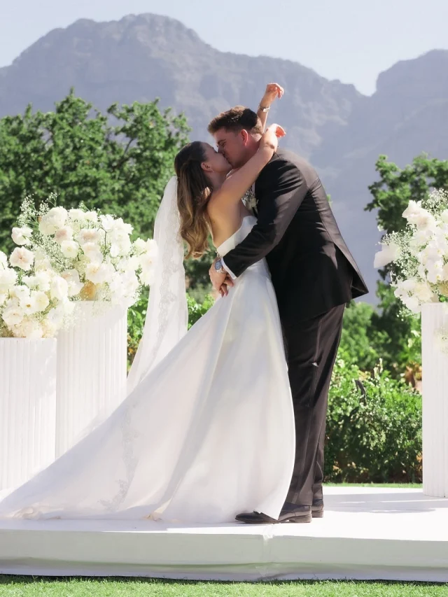 Bride and groom sharing a celebratory first kiss outdoors