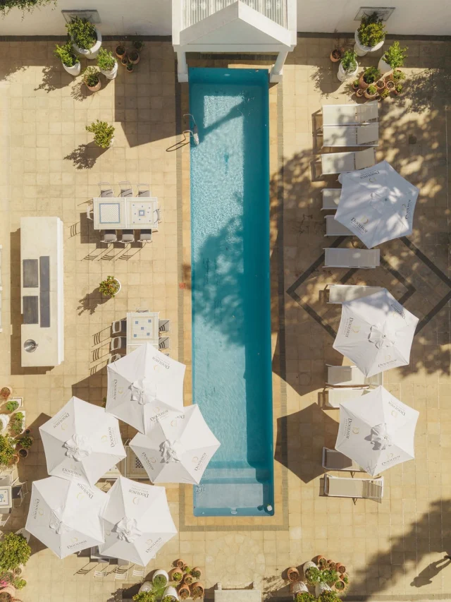 Aerial view of a venue courtyard with a pool and white umbrellas