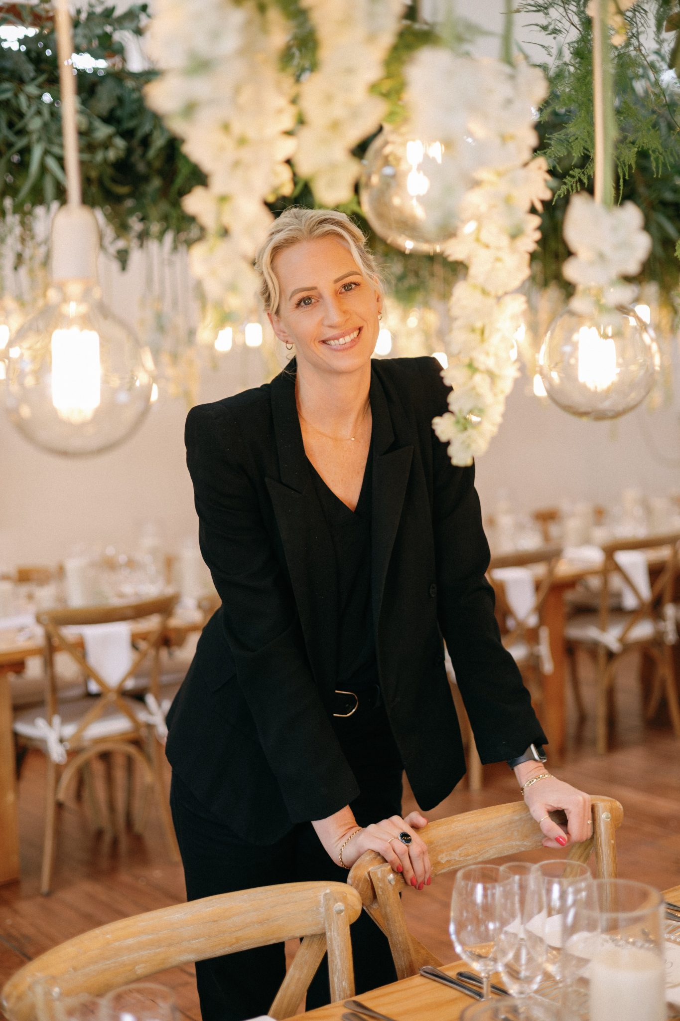 Nicolette Morris in a black blazer in a decorated wedding reception venue