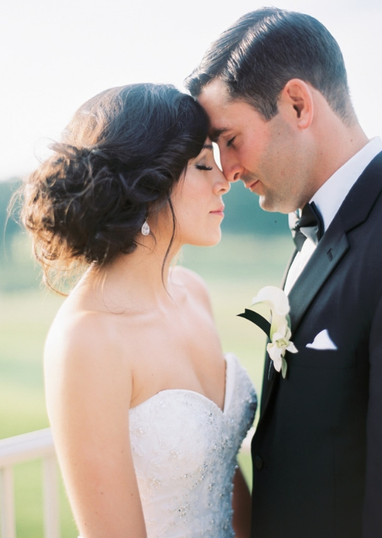 Bride and groom forehead to forehead outdoors on their wedding day
