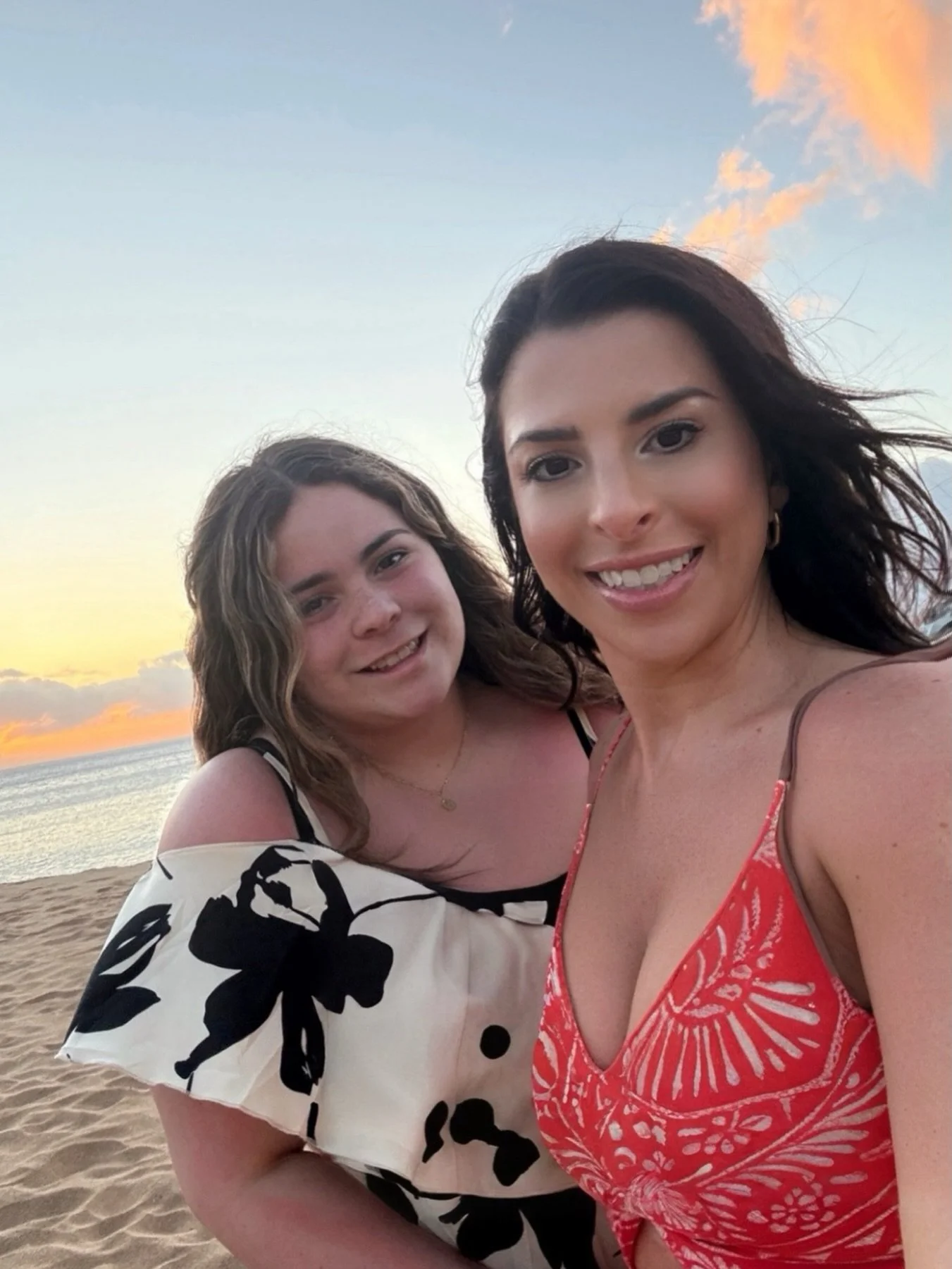 Gina with her daughter on the beach at sunset