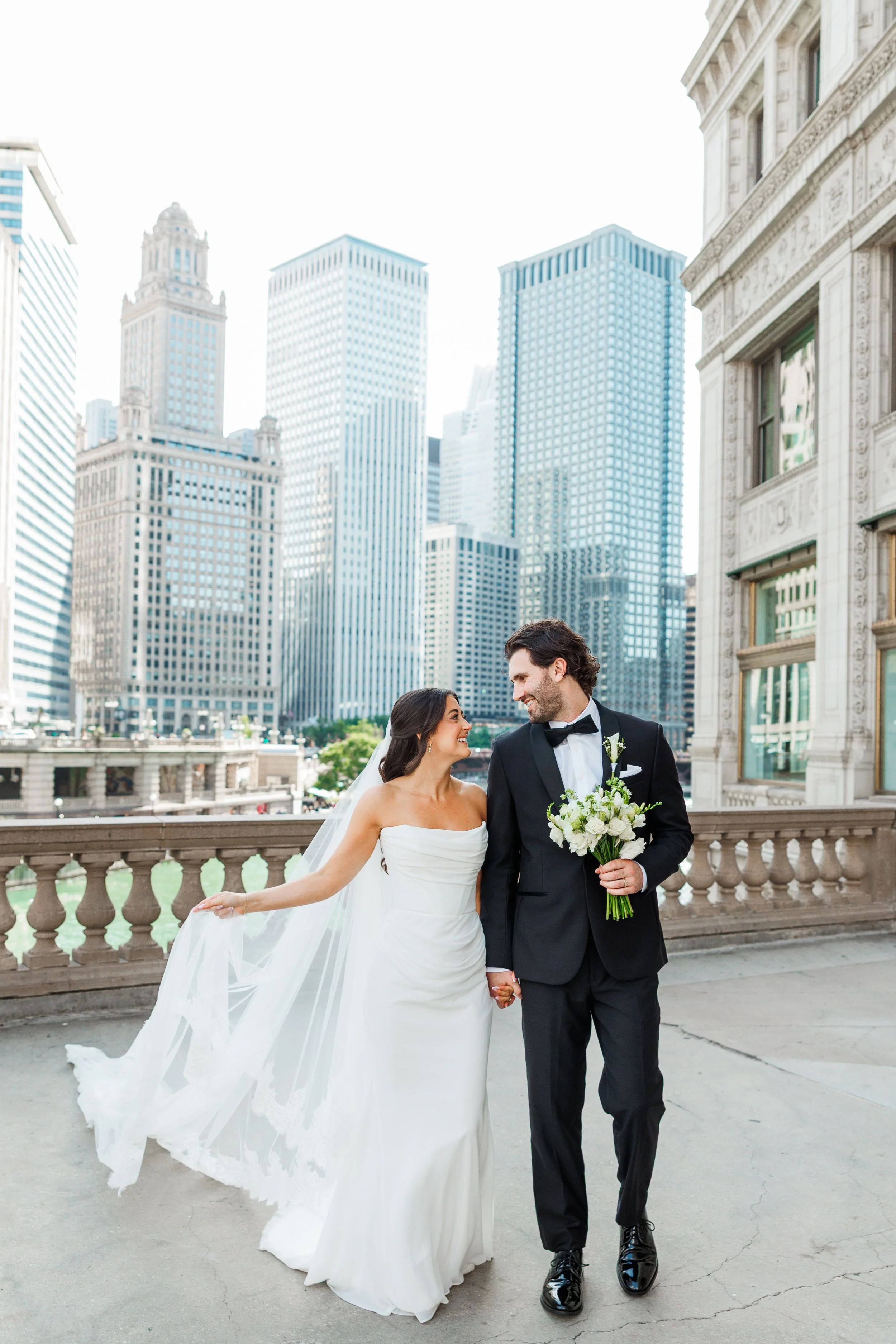 Bride and groom smiling on a terrace overlooking the Chicago River