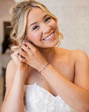 Bride putting on earrings