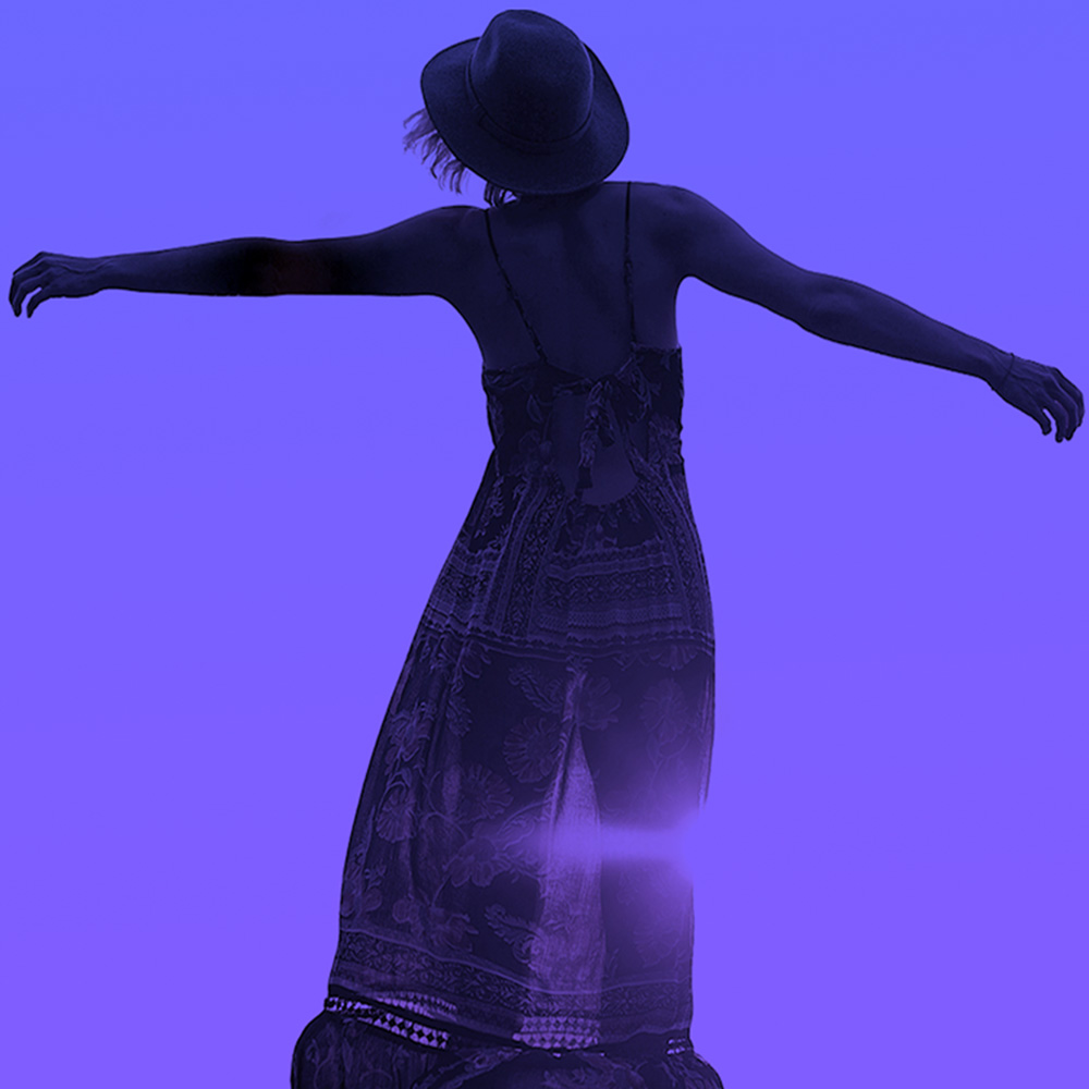 Silhouette of a woman with arms outstretched against a purple background