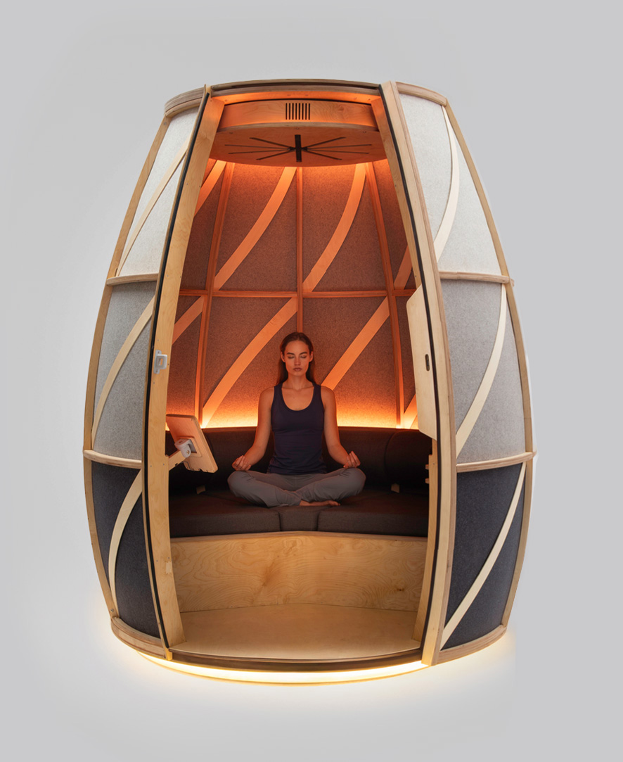 IRIS meditation pod, wood-framed, open with a woman meditating inside in warm amber light
