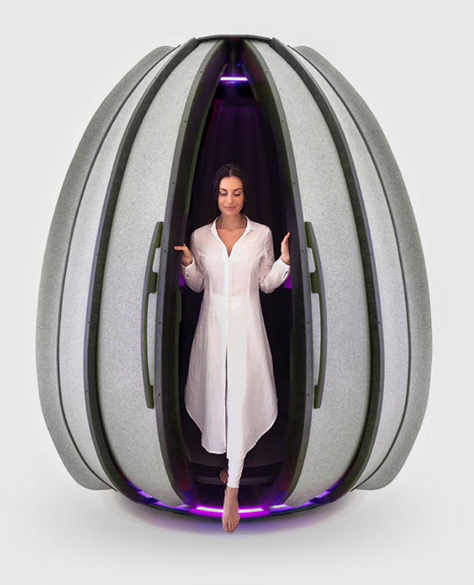 Woman in white standing inside an open LOTUS pod with purple interior LED lighting