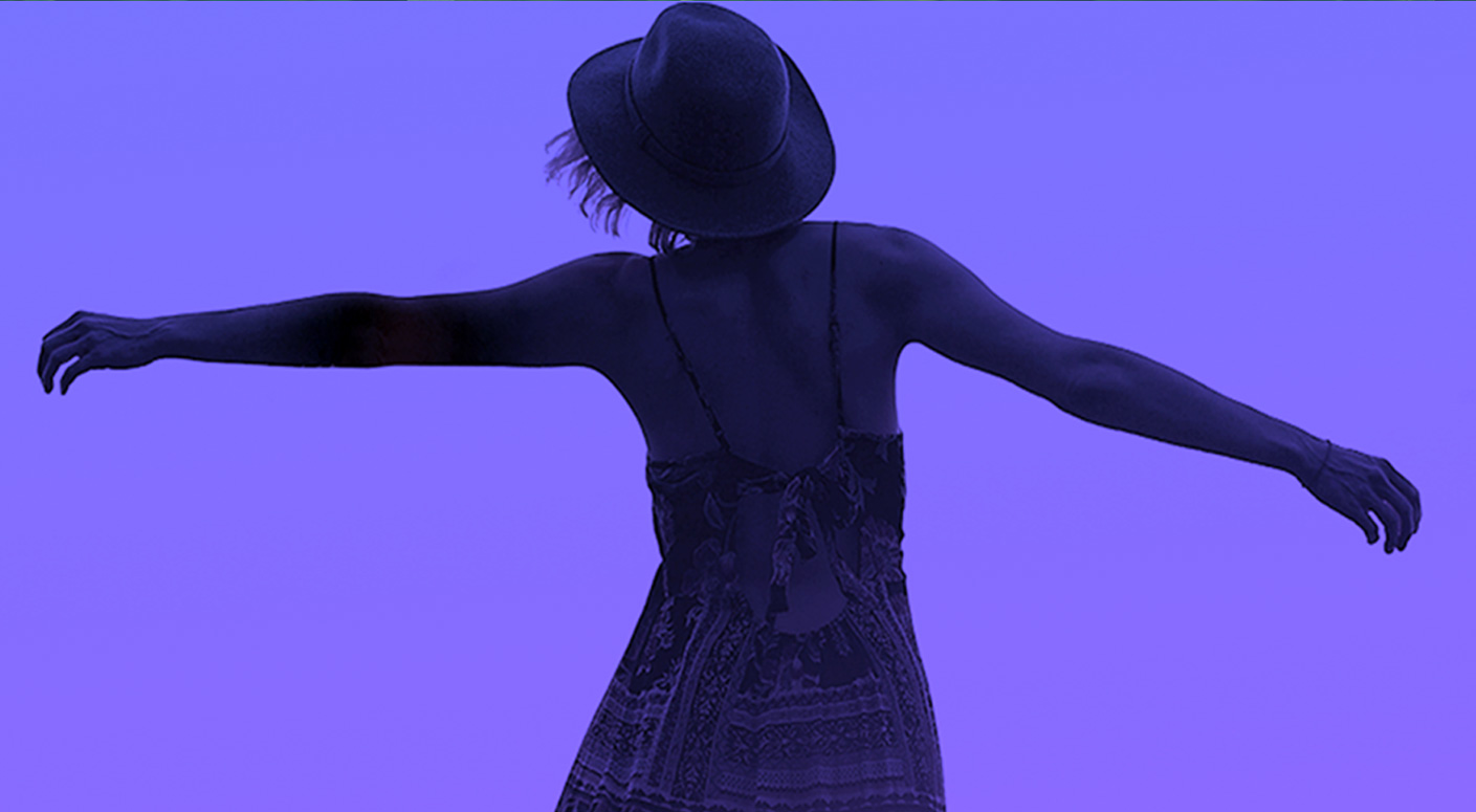 Silhouette of a woman with arms outstretched against a purple background