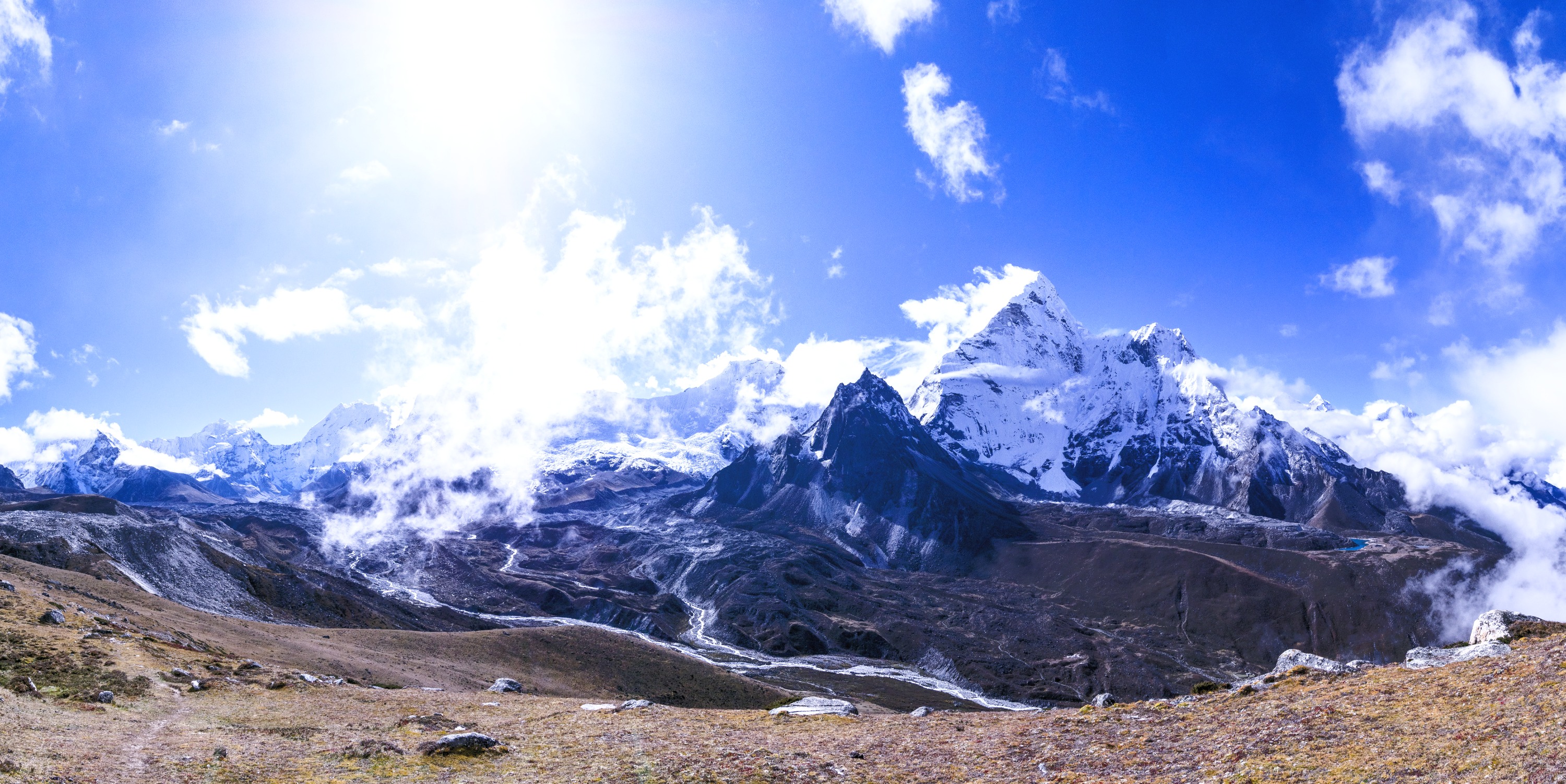 Panoramic view of Himalayan mountain peaks under a bright blue sky