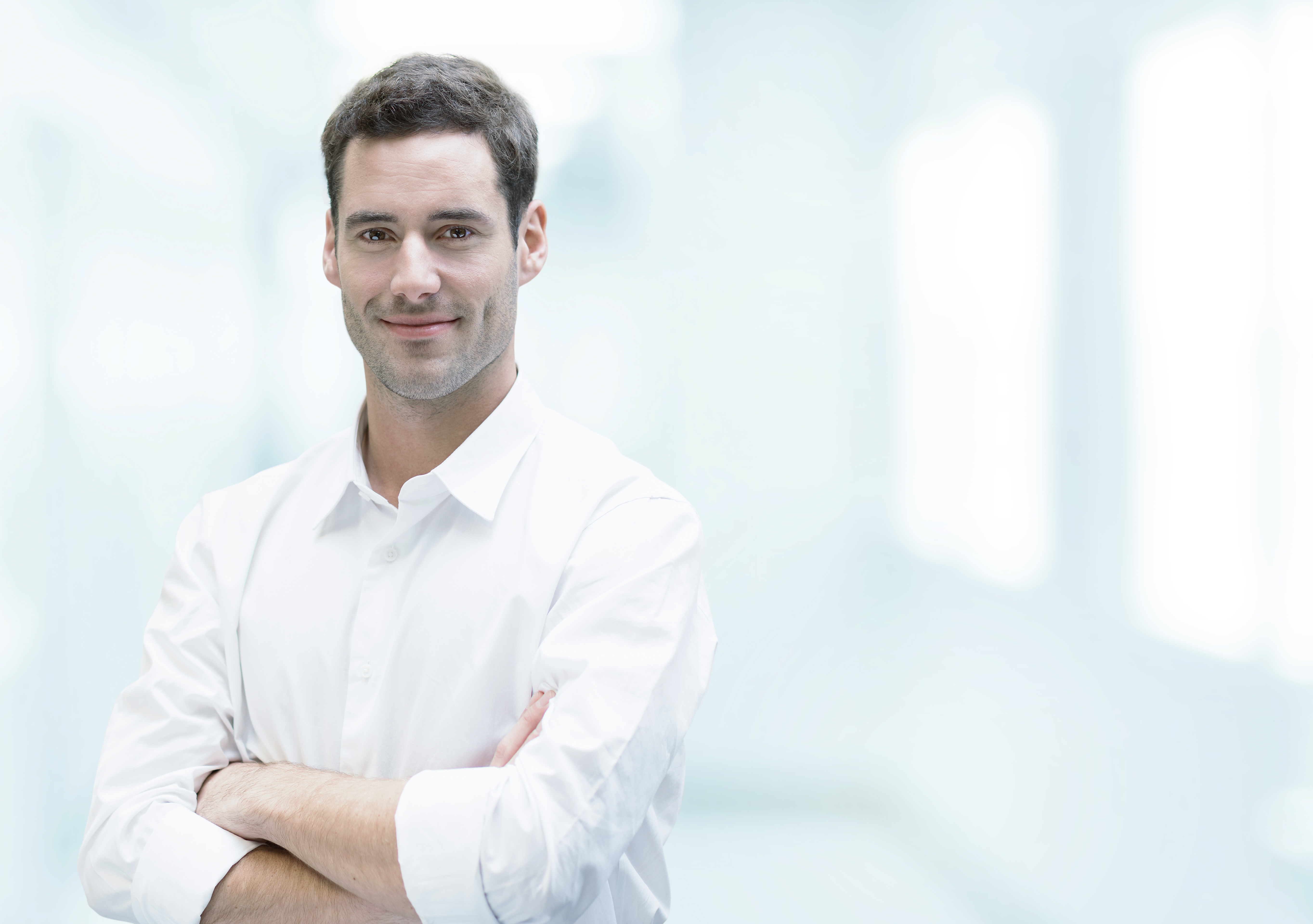 Young professional man with arms crossed, smiling