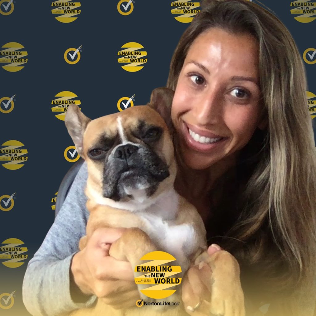 Woman holding a French bulldog at the NortonLifeLock event backdrop