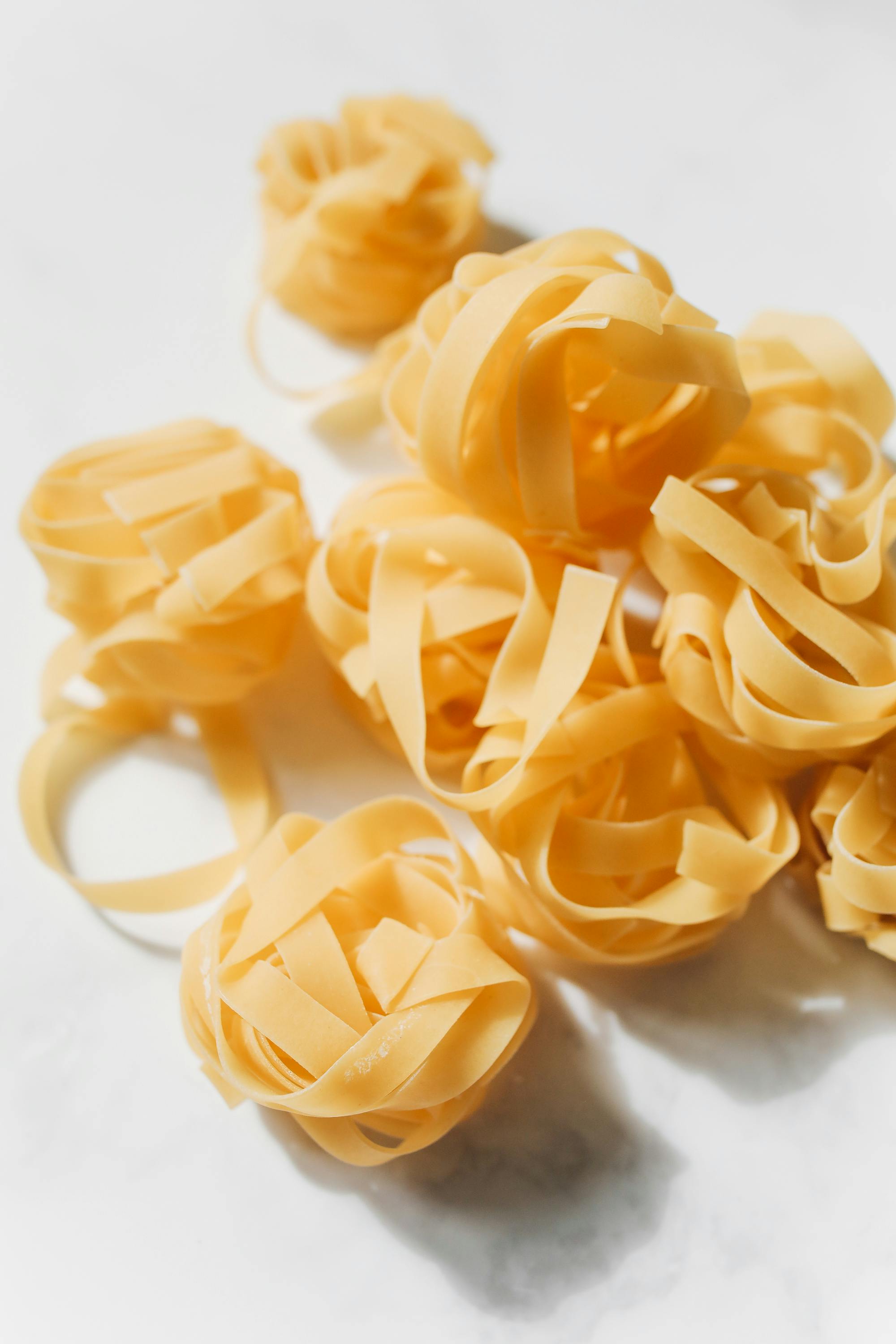 Dry tagliatelle nests, top-down studio shot