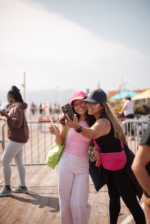 Two women taking a selfie at an outdoor pier event