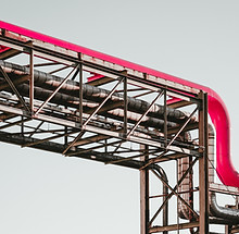 Industrial pipe structure against a blue sky representing venue infrastructure