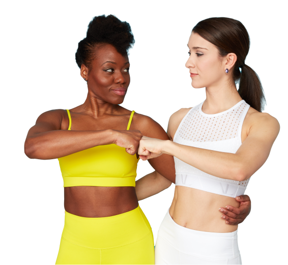 Two women fist-bumping in workout attire