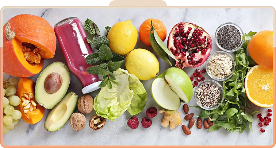 Flat-lay of fresh fruit, vegetables, nuts, greens and a smoothie bottle on marble at the Pickle1 Nourish Bar