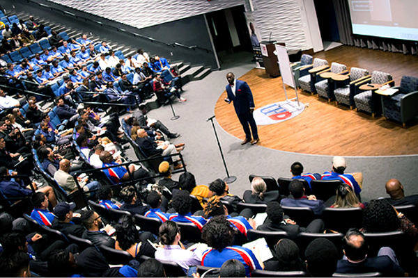 Aerial view of a keynote speaker on stage at a large auditorium